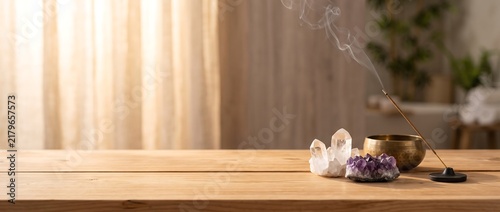 Incense smoke with healing crystals on wooden table for meditation and spiritual wellness