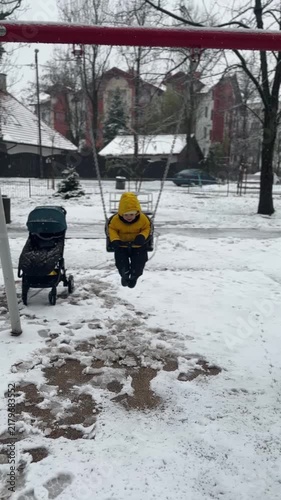 Toddler on swing in snow