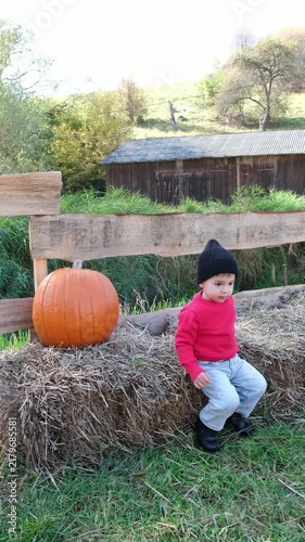 Boy sitting beside large pumpkin