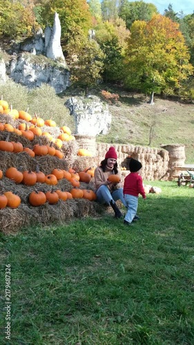 Child and parent near pumpkin wall