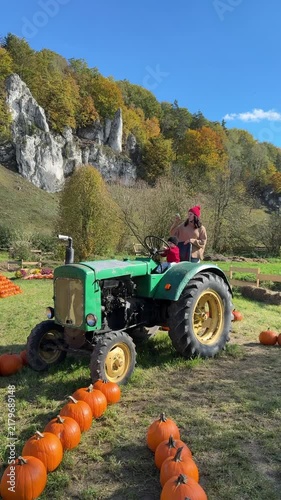 Child on tractor beside pumpkin rows
