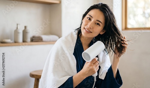 Young Woman Styling Wet Hair with Hair Dryer at Home