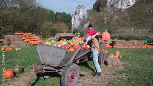 Mother and son by pumpkin farm cart
