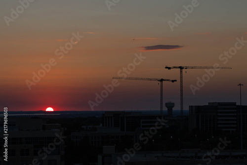 Construction cranes with beautiful sunset in the background