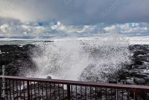 Big ocean waves crashing into rocky shore in Iceland