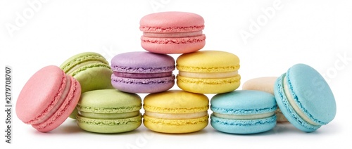 Colorful macarons stacked and scattered on white background
