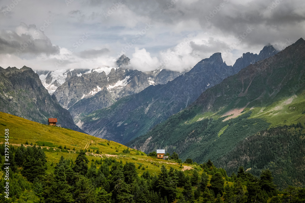 Obraz premium Mountain landscape in Svaneti on bright summer sunny day. Mountain lake, hills covered in green grass. Caucasus peaks in Georgia. Amazing view on wild georgian nature. 