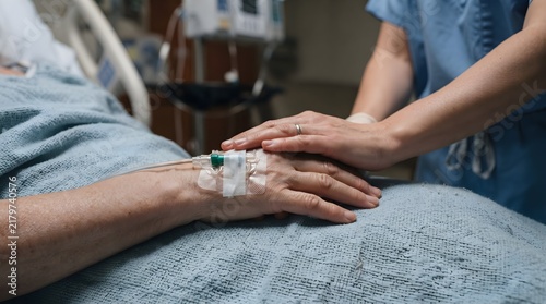 Nurse Supporting IV Patient's Hand During Authentic Bedside Healthcare