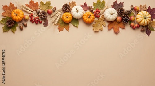 Autumnal arrangement of pumpkins and colorful fall leaves on a neutral background