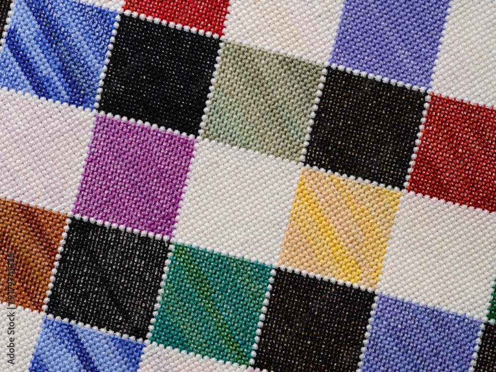 Fototapeta premium A close-up shot of a colorful checkered pattern hand-embroidered in cross-stitch.