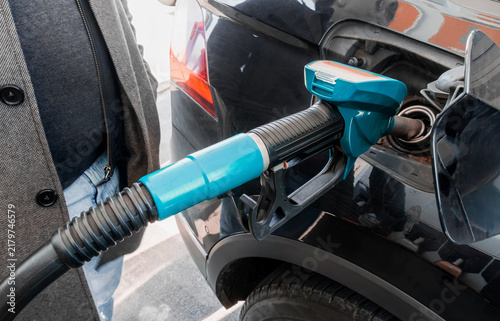 Foto Green fuel nozzle inserted into a car's tank at a gas station, refueling scene, european petrol station