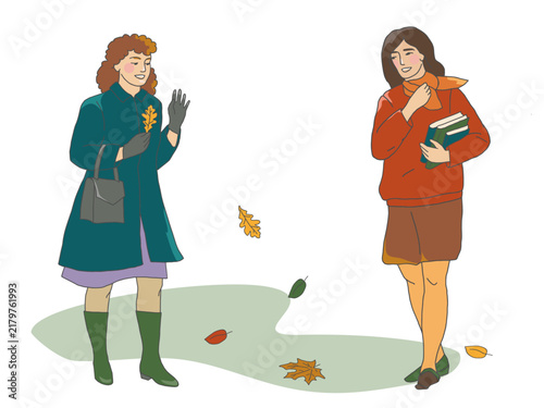 Two young women meeting and talking in autumn park, friends enjoying casual outdoor conversation on a fall day.