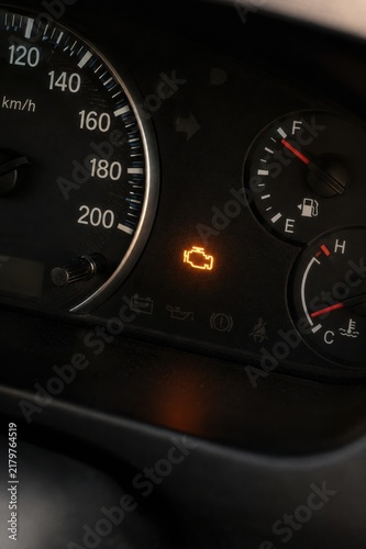 Glowing Check Engine Warning Light on Car Dashboard