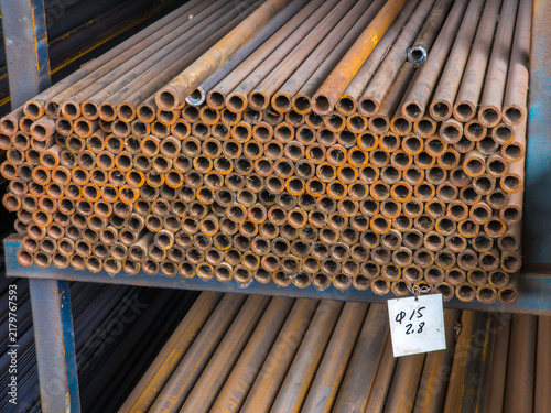 Stacked Rusty Metal Pipes on Industrial Shelf