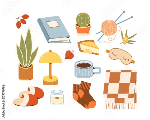 Cozy autumn home essentials set with books, plants, knitting, warm drink, slippers, socks, blanket, lamp and sleep mask.