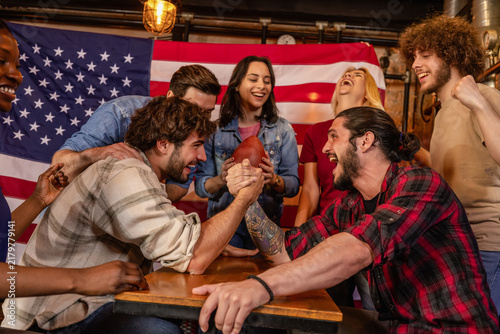 Foto Friends Watching Exciting Arm Wrestling Showdown in Pub