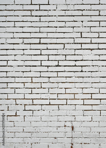 фотографія White painted brick and mortar wall showing flat smooth brick faces with cracked
