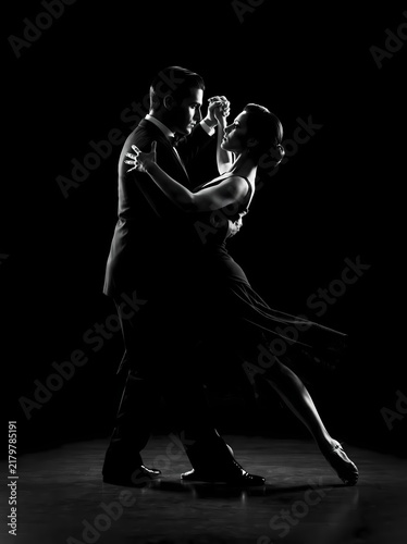Tango Dancers Displaying Passionate Connection in Elegant Formal Wear Against a Dramatic Black Background