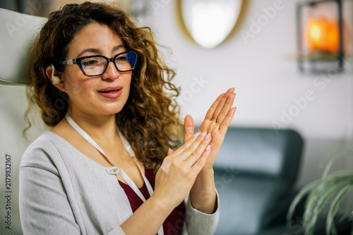 Woman Wearing Hearing Aid Signs While Working at Home