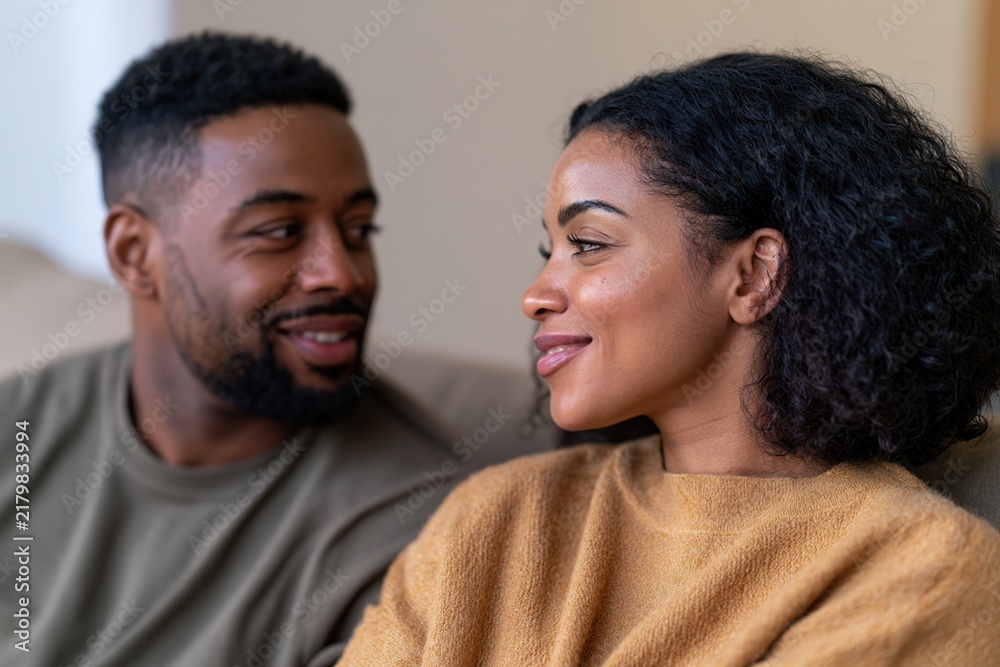 Obraz premium Couple sharing a reassuring conversation on a modern sofa at home