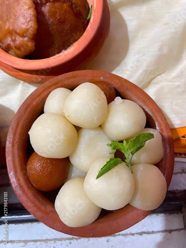 Foto Sweet Rasgulla and Gulab Jamun dessert assortment in clay pots with mint leaf