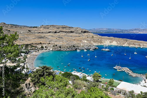 Turquoise bay with yachts and sandy beach, panoramic coastal view - Lindos, Rhodes Island, Greece