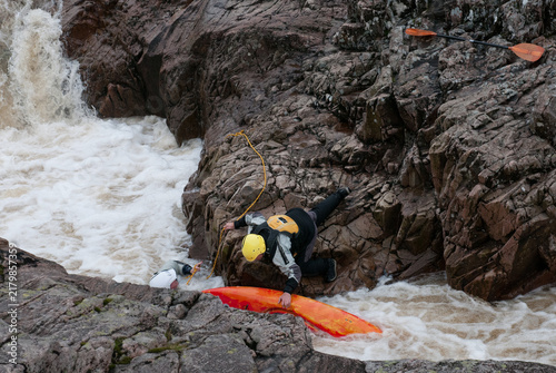 Kayaker instructor performing a rescue in a challenging whitewater river environment. People active, adventure extreme sport