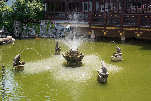 Photography Traditional Yu Garden water feature with fish statues spraying arcing streams in