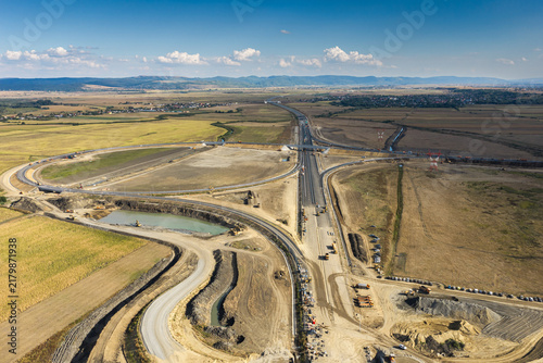 Aerial view of the Autostrada A7 highway road junction construction near Bacau, showcasing modern transportation infrastructure development on a bright sunny day. Moldova Highway in Romania