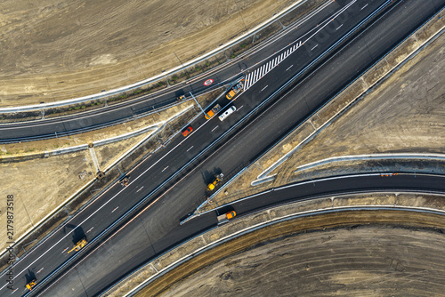Aerial top down view of highway interchange construction site on Autostrada A7 near Bacau, featuring asphalt paving machinery, ramps, markings and transport concept. Moldova Highway in Romania