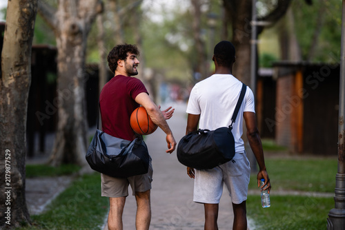 Obraz na płótnie Male friends walking to basketball game