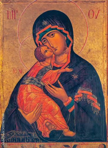 Fotografie A traditional icon depicts the Virgin Mary holding the infant Jesus Christ on golden background