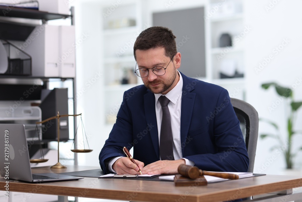 Obraz premium Professional lawyer signing paperwork at desk in office