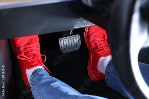 Fotografie Woman pushing accelerator pedal in car, closeup on foot
