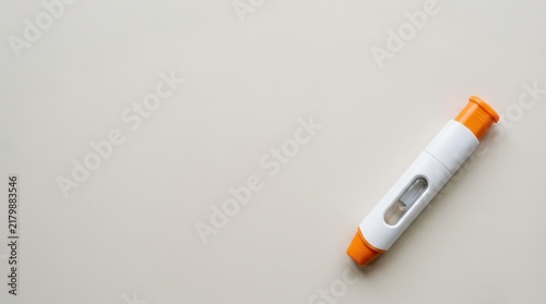 Epinephrine allergy injector pen on neutral beige background for medical emergency awareness poster and healthcare banner design. Copy space