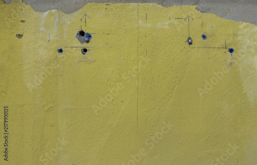  Yellow drywall marked with pencil for home renovation and installation drilled holes, installed anchors, and measurement marks