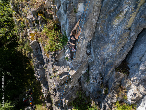 Obraz na płótnie Woman rock climbing a steep cliff outdoors