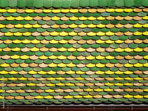 Close-up of a traditional colorful tiled roof in Alsace, France, featuring a decorative pattern of green and terracotta roof tiles.