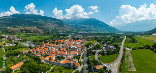 Принти на полотні Aerial drone panoramic view of the medieval walled town of Glurns (Glorenza) with red roofs, mountains and green valley in South Tyrol, Italy