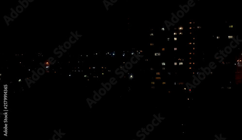 Dark night view of glowing illuminated apartment building windows in a residential city district in winter Russia.