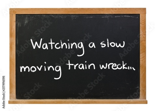 Картината върху платно Watching a slow moving train wreck written in white chalk on a black chalkboard