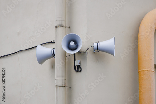 Cuadro en lienzo Three white horn speakers mounted on wall with pipes