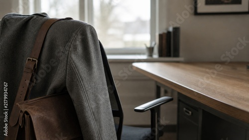Wool coat and leather satchel draped over an office chair