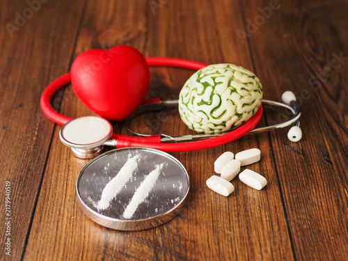 Konstfotografi Stethoscope rests beside brain model and tow line of drugs on small mirror on wooden surface