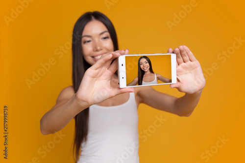 Fotografía Woman showing smartphone screen with selfie camera preview