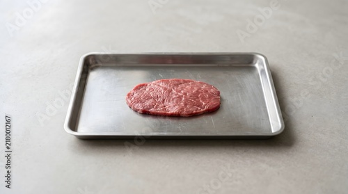 Thin meat slice sample on clean steel tray, cultivated meat product and future food concept