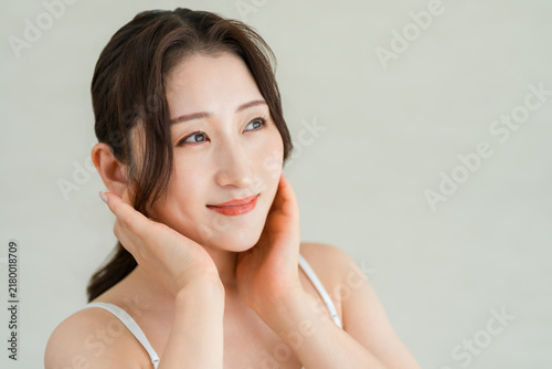 Quadro su tela A mature woman checking her beautiful skin by placing her hand on her cheek: skincare and beauty image