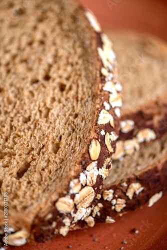 Canvastavla Close-up of sliced multigrain bread with oats on a wooden surface