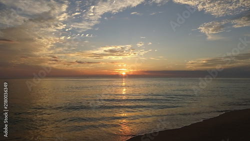 Konstfotografi Sun Cresting Over Horizon with Sandy Beach Foreground