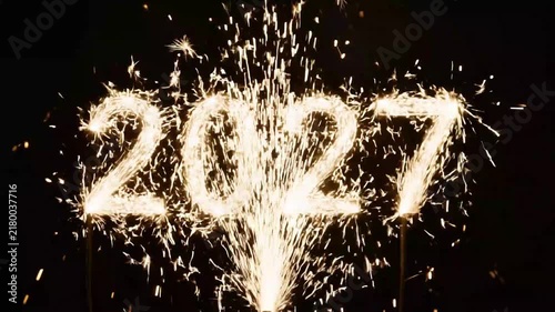 Sparkling 2027 year numbers burning with bright fireworks against black on transparent background